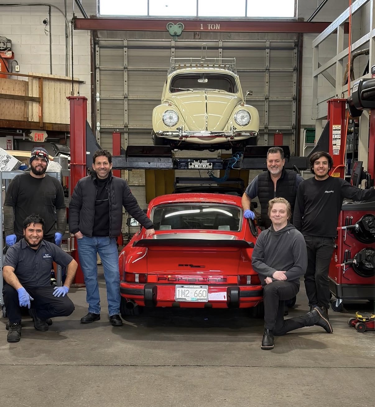 The Juan's Auto Service team with a Porsche 911 and classic VW Beetle